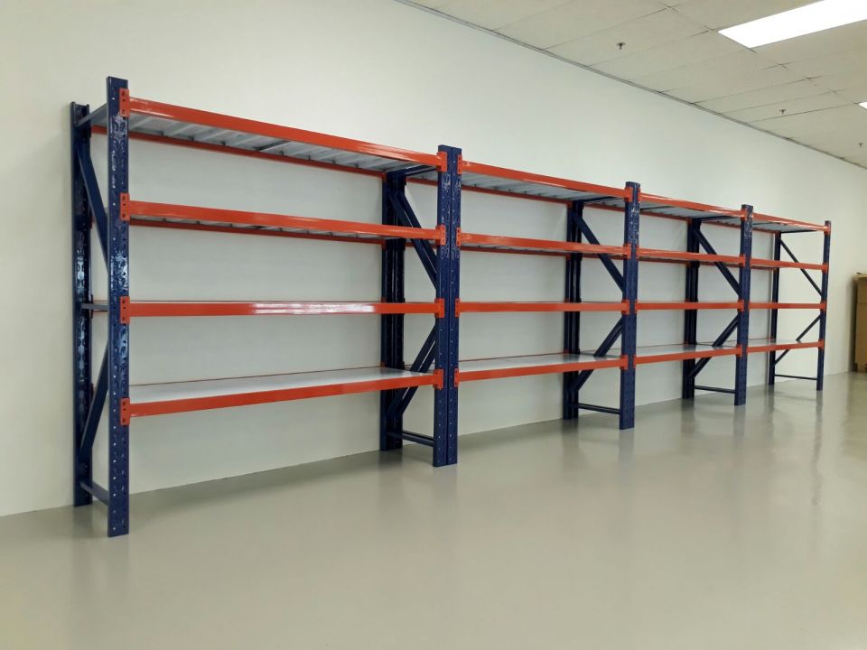 Long run of blue and orange boltless warehouse racks installed along an office wall in Singapore