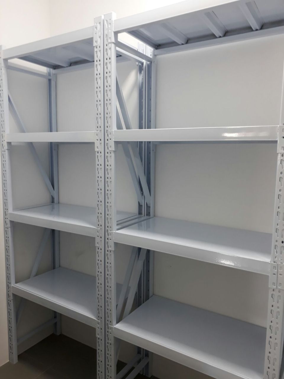 Close view of white boltless racks with smooth steel shelves